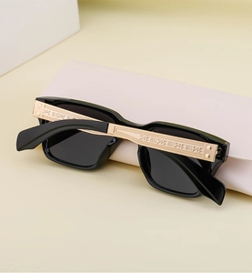 Detail of polarized sunglasses showing golden temples with intricate geometric engraving