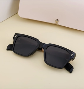 Detail of square polarized sunglasses with golden arrow rivets on glossy black frames