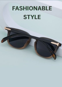 Close-up of square sunglasses featuring black and brown frames with gold metal temple details