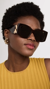 Close-up of tortoise shell cat-eye sunglasses with gold metal chain temple detail