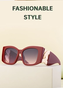 Close-up of cat-eye sunglasses with burgundy frame and golden chain detail on temples