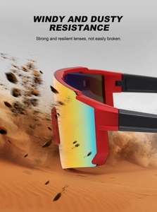 Detail view of windproof cycling sunglasses with red frame and gradient lens on sand