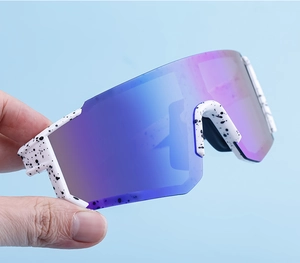 Close-up of white paint-splattered cycling sunglasses with purple gradient lens