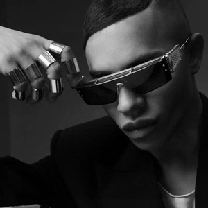 Close-up of steampunk square sunglasses and polished silver rings in Y2K street style