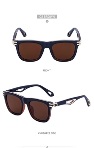Detail view of square black sunglasses with brown lenses and golden metal cut-out accents