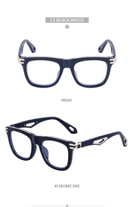 Close-up of square black sunglasses with gold metal hinges and geometric hollow temples