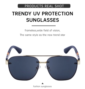Detail view of rimless sunglasses with gold bridge and striped temple arms