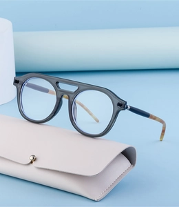 Steampunk sunglasses with grey frame and faux leather case on blue geometric background
