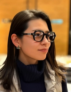 Close-up of retro black square frame sunglasses with luxury satellite planet earrings
