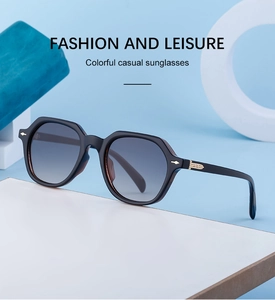 Detail of black hexagonal sunglasses with grey gradient lenses and gold temple accents