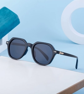 Detail of retro black sunglasses with grey lenses and elegant gold hinge accents