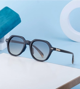 Detail of retro square sunglasses with black frame, gradient lenses and gold temple accents