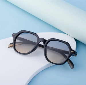 Detail of retro geometric sunglasses with gradient lenses and golden hinge accents