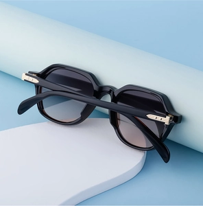 Detail view of black geometric sunglasses with elegant gold streamlined metal accents