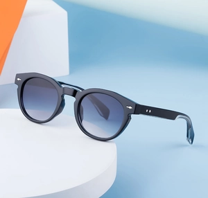 Detail of oval sunglasses with black frames, blue lenses and silver diamond rivets