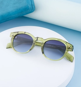 Detail of light green oval sunglasses frame with ZS98092 model number on the temple