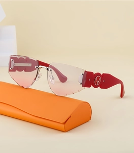 Detail view of red rimless sunglasses with gradient lenses and deer logo on wide temples