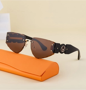 Detail of rimless carved sunglasses with wide black temples and deer logo next to orange case
