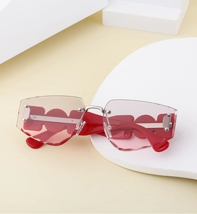 Detail of red geometric temples and rimless carved lenses of these trendy sunglasses