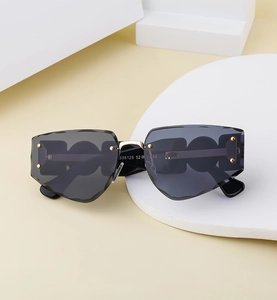 Detail of rimless sunglasses featuring faceted lens edges and three circle cutout temples