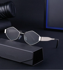 Détail de lunettes hexagonales argentées avec leur étui noir à texture tressée élégant