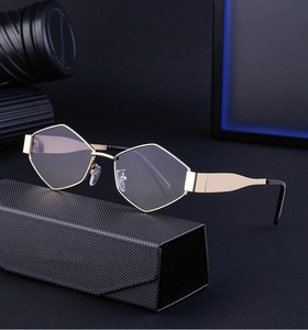 Détail de lunettes de soleil géométriques or et noir sur un étui matelassé chic