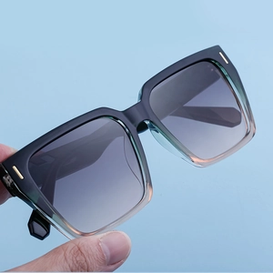 Details einer eckigen Farbverlauf-Sonnenbrille mit goldenen Metallbesätzen