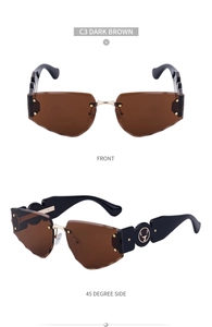 Detail of dark brown rimless wavy cut sunglasses with golden stag logos on wide temples