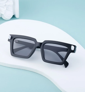 Detail view of matte black square sunglasses with rectangle lenses on a white pedestal