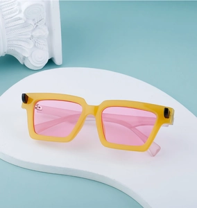 Close-up of retro rectangular sunglasses with yellow frames and pink tinted lenses