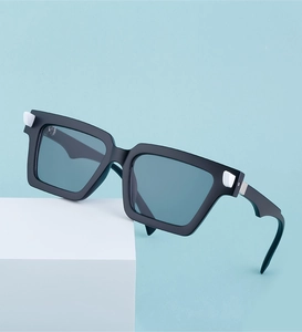 Close-up of square sunglasses with blue lenses and white accents on a blue backdrop