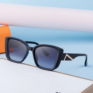 Lunettes de soleil œil de chat modernes avec verres dégradés et détails dorés sur socle