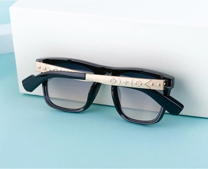 Detail of square sunglasses with gold bohemian engraved temples and gradient grey lenses
