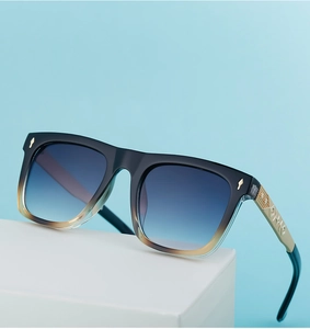 Detail of square sunglasses featuring golden engraved temples with intricate patterns
