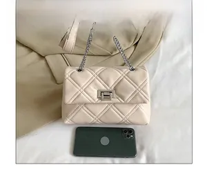 Detailed size comparison of the beige quilted chain bag with a smartphone