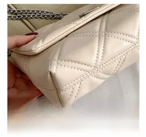Detail showing precise stitching and quilted pattern on beige crossbody chain bag