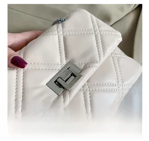 Macro shot of beige quilted leather texture and silver metal twist lock closure