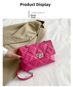 Detail of deep pink quilted crossbody bag with silver lock and metal chain strap