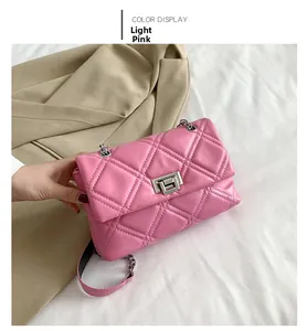 Detail of light pink quilted crossbody bag with silver metal chain and twist lock
