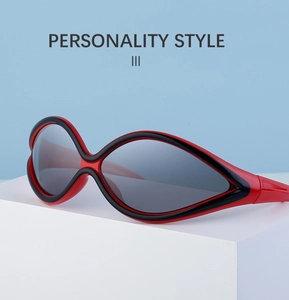 Detail view of bold red and black Y2K cat-eye cycling sunglasses on a white block