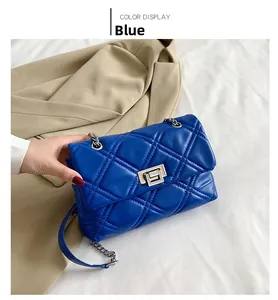 Close-up of blue quilted PU leather bag with silver metal chain and rotary lock