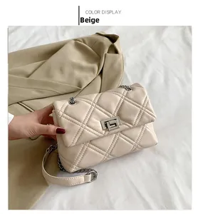Detail of beige quilted flap bag featuring silver metal twist lock and sleek leather texture