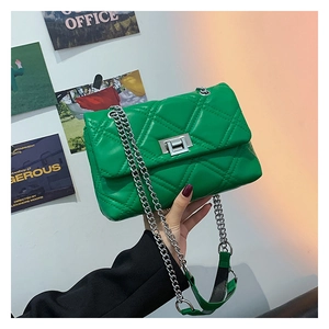 Close-up of green quilted shoulder bag with silver chain strap and metal turn-lock