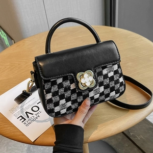 Elegant women's crossbody bag with black-and-white woven pattern and golden clover clasp