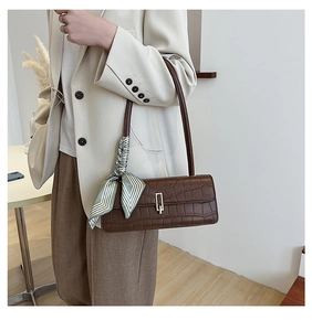 Détail du sac à bandoulière marron foncé motif crocodile avec poignée en foulard