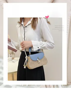Detail of straw woven bag with light blue leather flap and rope strap with metal orb