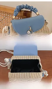 Detail view of woven straw bag with blue leather flap and floral metal lock buckle