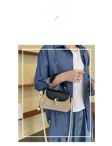 Macro detail of straw woven crossbody bag featuring black leather flap and gold turn lock