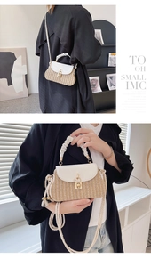Detail of woven straw handbag with ruffled handle and white leather flap closure