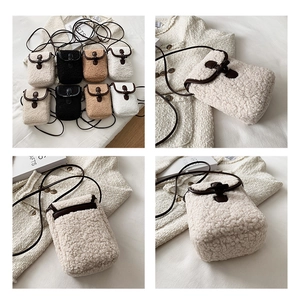 Detail view of plush fleece crossbody bags with leather buckle straps in four colors